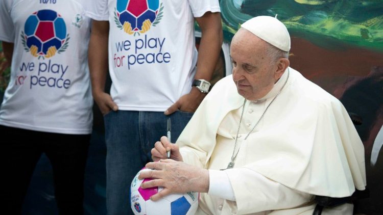 El Papa firma un balón durante la inauguración de la Escuela Laudato Si' de Scholas Occurrentes en mayo de 2022. (ANSA) 