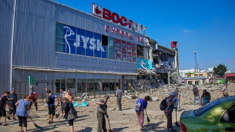 Voluntários limpam destroços perto de um shopping danificado após bombardeio noturno em Kharkiv, Ucrânia, 08 de junho de 2022. Uma pessoa foi morta e três ficaram feridas no bombardeio do dia anterior, disse o prefeito de Kharkiv, Terekhov. EPA/SERGEY KOZLOV
