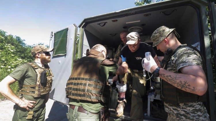 Militares ucranianos ayudan a un compañero herido a recibir los primeros auxilios cerca de la línea del frente en la zona de Donetsk, 10 de junio de 2022