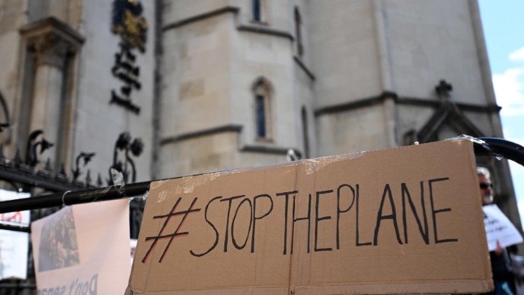 Un cartello davanti all'Alta Corte di Londra chiede lo stop degli aerei previsti per l'espulsione di richiedenti asilo in Rwanda