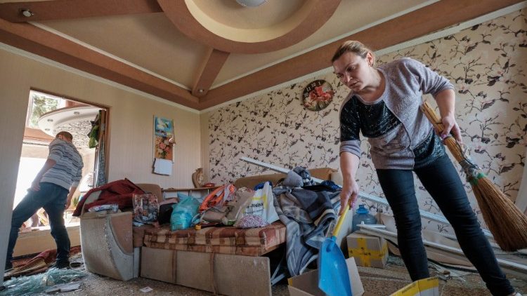Moradores limpam detritos de um apartamento danificado em um prédio residencial após um recente ataque de foguete, na pequena cidade de Selidovo, na área de Donetsk, Ucrânia, em 16 de setembro de 2022, em meio à invasão russa. EPA/YEVGEN HONCHARENKO