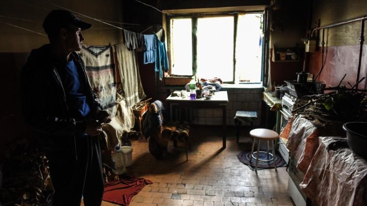 Um homem está dentro de uma cozinha, onde os moradores cozinham em fogo aberto, pois o gás e a eletricidade não estão disponíveis, em um prédio residencial em Izyum, região de Kharkiv, nordeste da Ucrânia, 19 de setembro de 2022. EPA/OLEG PETRASYUK