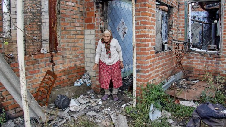 A woman amidst the ruins of destroyed buildings in Kharkiv
