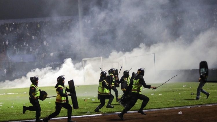 Forze dell'ordine intervengono dopo l'irruzione di tifosi facinorosi nel campo dello stadio di Malang, in Indonesia
