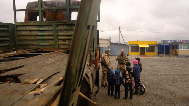 Children talk with Ukrainian soldiers near Kupiansk