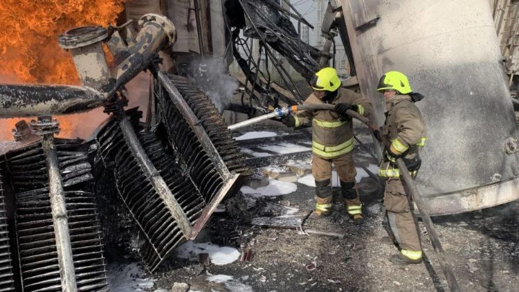 Ua foto di soccorritori all'opera dopo un bombardamento russo (Ansa)