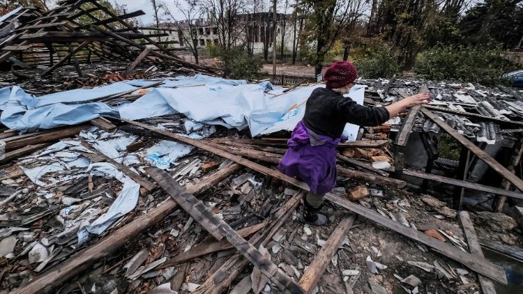 Tatyana Litvin, de 64 anos, trabalha no telhado desabado de sua casa na vila recapturada de Osokorivka, Ucrânia, em 25 de outubro de 2022. A vila foi libertada pelas forças ucranianas no início de abril, mas desde então ainda está sob fogo contínuo de Exército russo. As tropas russas entraram em território ucraniano em 24 de fevereiro, iniciando um conflito que provocou destruição e uma crise humanitária. EPA/HANNIBAL HANSCHKE