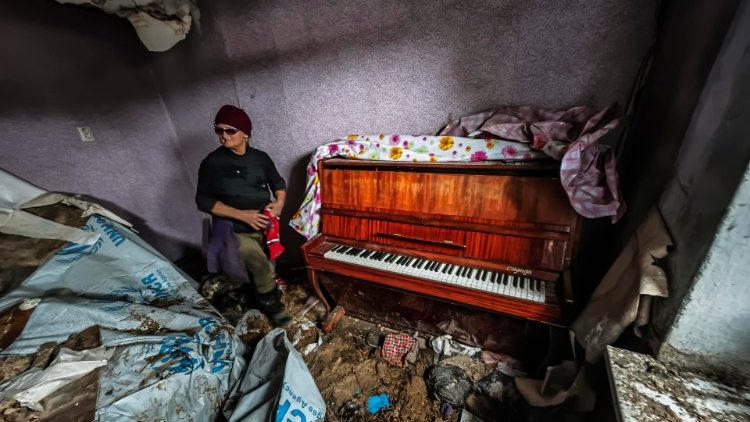 Tatyana Litvin, 64 anos, apresenta um piano que ela poderia salvar em sua casa na vila recapturada de Osokorivka, Ucrânia, 25 de outubro de 2022. A vila foi libertada pelas forças ucranianas no início de abril, mas desde então ainda está sob fogo contínuo do exército russo. As tropas russas entraram em território ucraniano em 24 de fevereiro, iniciando um conflito que provocou destruição e uma crise humanitária. EPA/HANNIBAL HANSCHKE