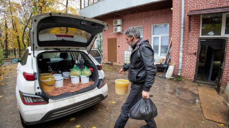 Um voluntário ucraniano carrega alimentos para entregar a pessoas necessitadas, hospitais e asilos em Kharkiv, Ucrânia, 26 de outubro de 2022. EPA/SERGEY KOZLOV