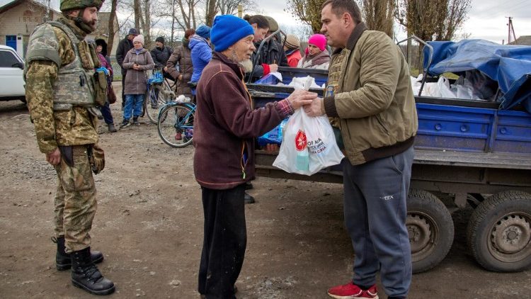 Voluntários e militares ucranianos distribuem ajuda humanitária aos habitantes locais no território recentemente recapturado de Kupiansk, no nordeste da Ucrânia. EPA/SERGEY KOZLOV