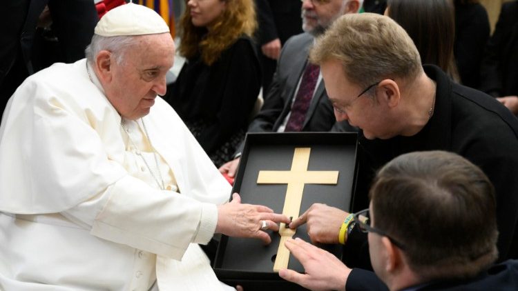 Mer Lwowa, Andrij Sadowy, przekazujący Papieżowi specjalny krzyż z odłamkiem rosyjskiej rakiety; mer ma na ręce bransoletkę projektu "Unbroken"; 7 grudnia 2022 r.