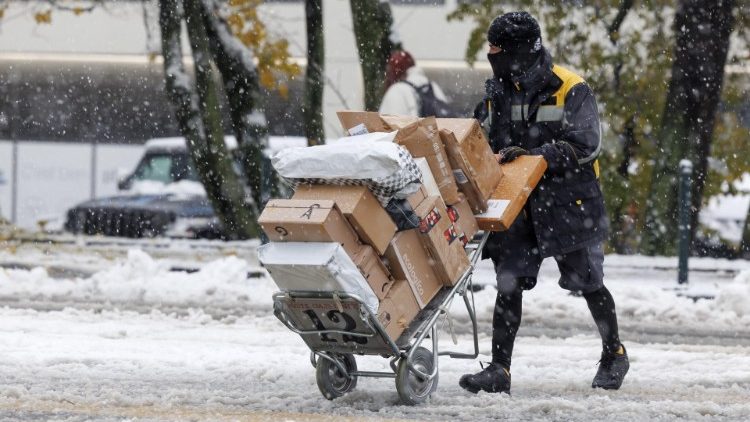 A postal worker in Switzerland hauls a cartload of mail