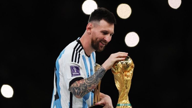Il capitano dell'Argentina Lionel Messi accarezza la Coppa del mondo appena vinta