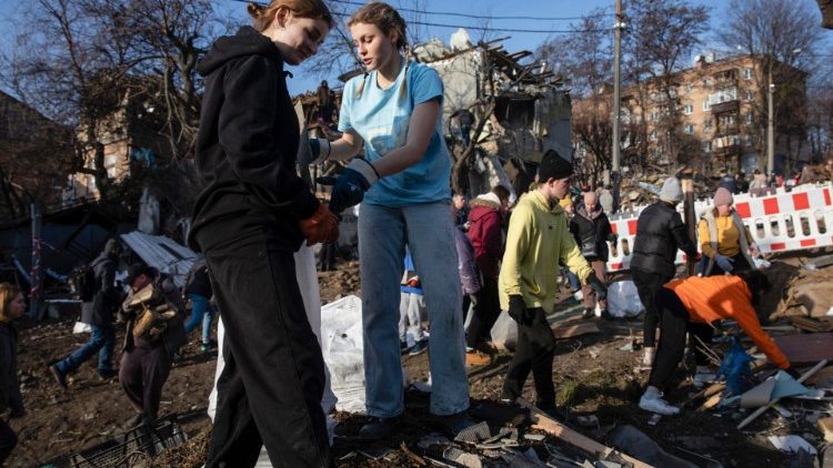 Voluntários limpam detritos no local de um ataque de míssil russo ocorrido em 31 de dezembro de 2022 em Kyiv, Ucrânia, 03 de janeiro de 2023. Mísseis russos atingiram as principais cidades da Ucrânia em 31 de dezembro, antes da celebração do Ano Novo. As tropas russas entraram na Ucrânia em 24 de fevereiro de 2022, iniciando um conflito que provocou destruição e uma crise humanitária. EPA/MIKHAIL PALINCHAK