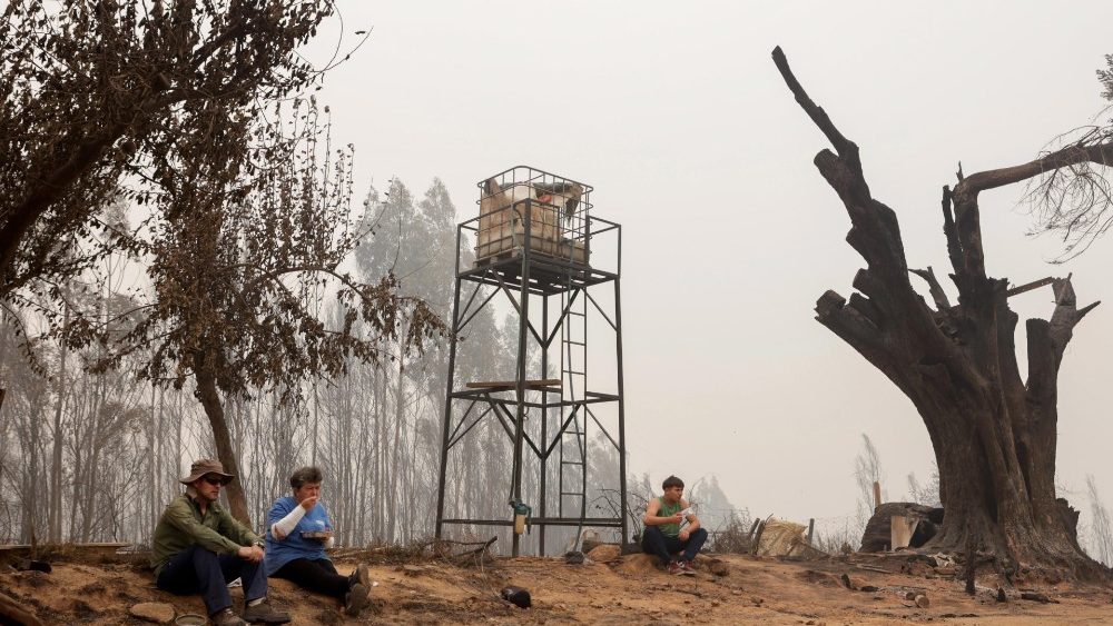 Inhabitants rest after efforts to recover belongings after a fire, in Santa Juana, Chile, 05 February 2023. More than 800 people have been left homeless in Chile due to forest fires that have been raging in central Chile for three days, with the flames still advancing from the hills towards the sea in the Biobio region. EPA/Esteban Paredes Drake
