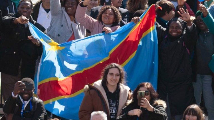 Congolese nationals holding the flag of the DRC during the Angelus of 12. 02. 2023.