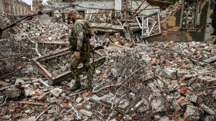 Um militar ucraniano da 24ª brigada mecanizada caminha entre as ruínas de um prédio destruído por ataques de mísseis russos na região de Donetsk, Ucrânia, em 20 de julho de 2023. EPA/OLEG PETRASYUK