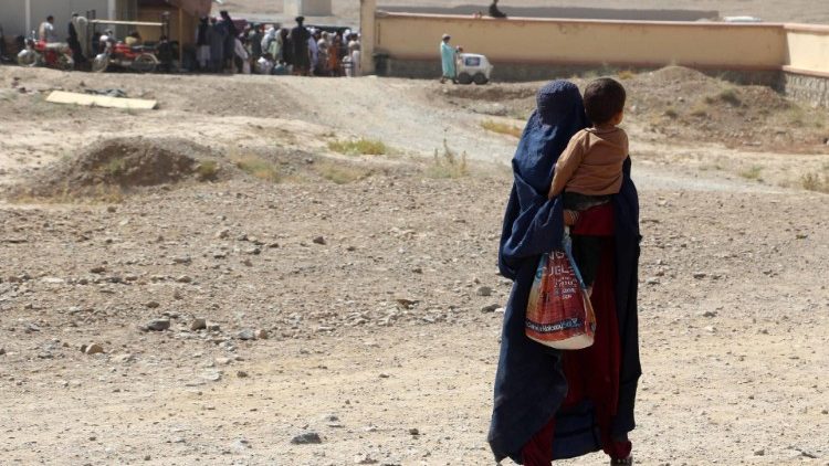 An Afghan woman waits to receive food rations