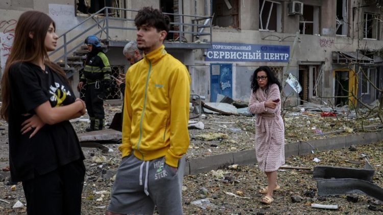 Moradores ficam entre os escombros após um ataque com foguete em Kharkiv, leste da Ucrânia, em 6 de outubro de 2023. EPA/YAKIV LYASHENKO