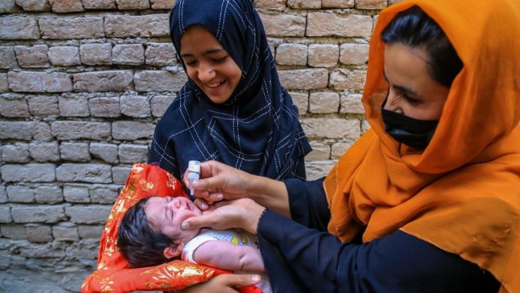Health workers administering polio vaccin to a child in Kabul