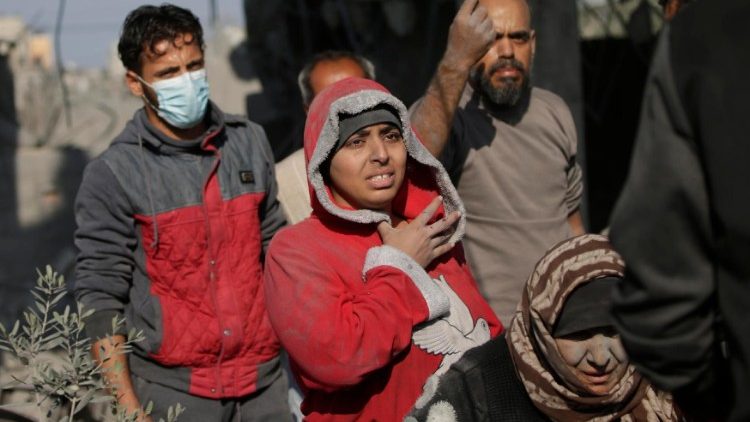 Palestinians at the site of a destoyed family house during an Israeli operation in Khan Younis