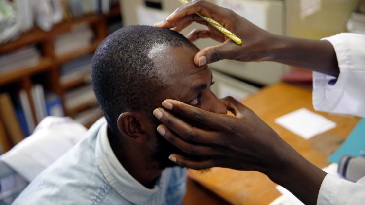 IOM's HIV adherence counsellor examines an HIV positive patient at a treatment centre 