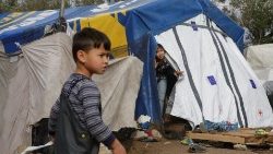 children-look-on-at-a-makeshift-camp-next-to--1543589347917.JPG