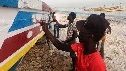 men-paint-a-fishing-boat-on-a-beach-in-dakar--1543841048888.JPG