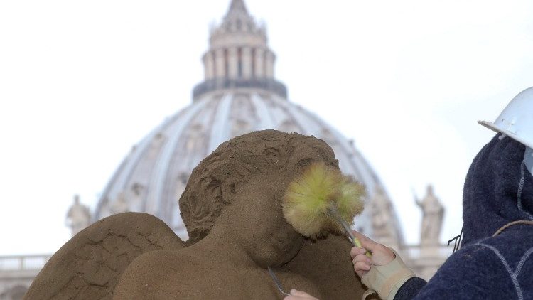 An artist works on a sand sculpture representing part of nativity scene in St. Peter's square at the Vatican
