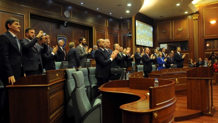 Kosovo's lawmakers applaud after approving the formation of a national army