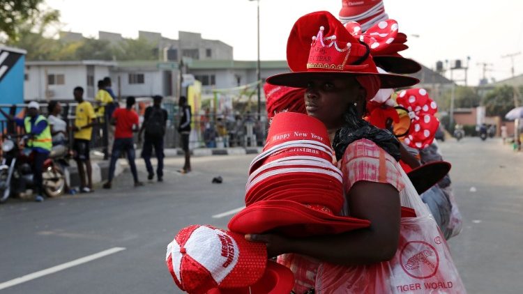 Street vendors sell hats and Christmas items along a street in Lagos