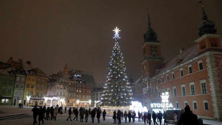 People walk near a Christmas tree in front of the Royal Castle in Warsaw
