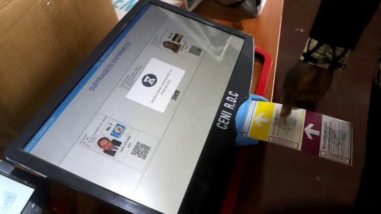 A worker of Congo's National Independent Electoral Commission (CENI), tests a voting machine ahead of the postponed presidential election, at the CENI offices in Kinshasa