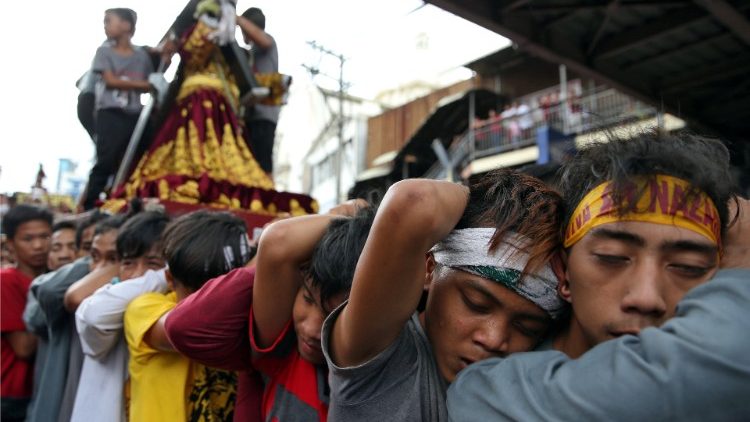 Devotees pull a chariot as they parade a replica of the Black Nazarene, two days before the annual procession to celebrate its feast day in Quiapo, Manila