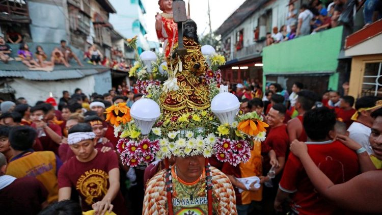 Catholic devotees celebrate as they wait to touch the statue of the Black Nazarene on its feast day in Manila