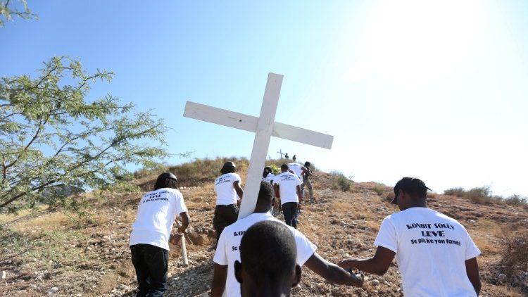 Pessoas carregam uma cruz em memória das vítimas do terremoto de  2010, em Porto Príncipe