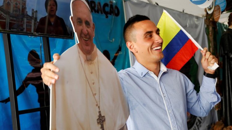 A Catholic pilgrim poses with a cardboard cutout of Pope Francis during an event at a park, ahead of Pope Francis' visit for World Youth Day in Panama City