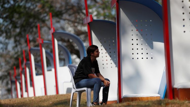 Catholic pilgrim waits to confess at public confessional stands at Omar Park as part of World Youth Day in Panama City