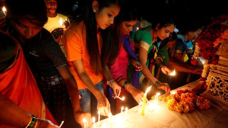 People light candles at a memorial during a vigil after a suicide bomber rammed a car into a bus in south Kashmir last week, in Ahmedabad