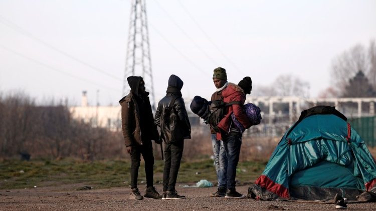 El 21 de febrero de 2019, personas que llevaban sus pertenencias después de haber sido perseguidas por las autoridades francesas en Calais, Francia.
