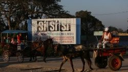 people-riding-horse-carts-pass-by-a-billboard-1550765727618.JPG