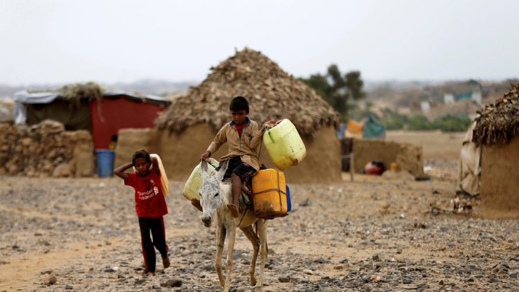 Un bambino in Yemen con delle taniche di acqua
