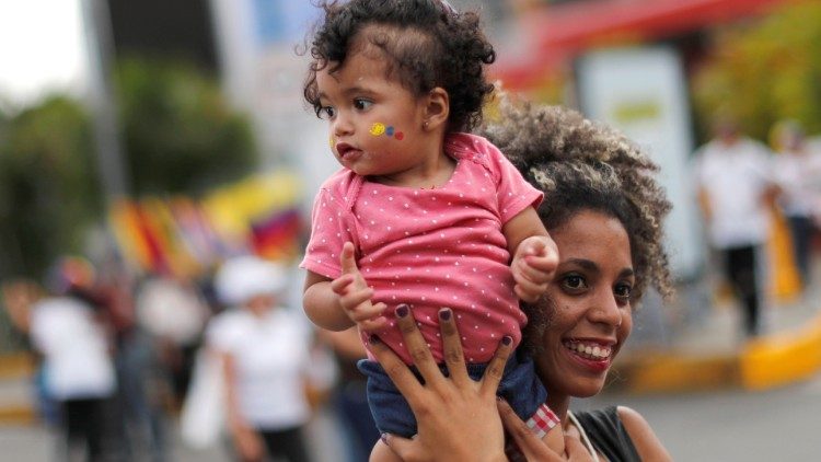 Venezuelansk kvinna med barn i famnen