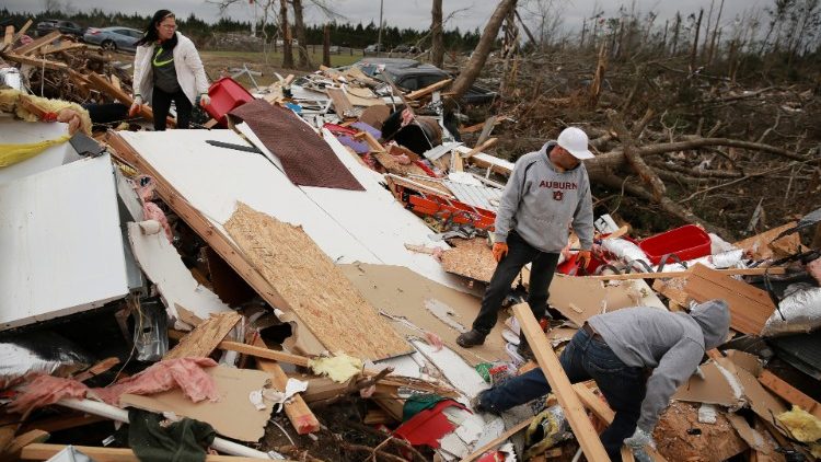 People look through the wreckage of their friend's home after two back-to-back tornadoes touched down, in Beauregard