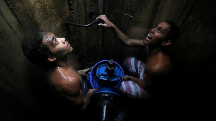 Residentes colectan agua de una tubería subterránea en Caracas