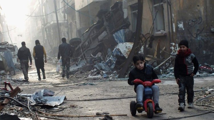 Crianças brincam em meio à destruição em Homs