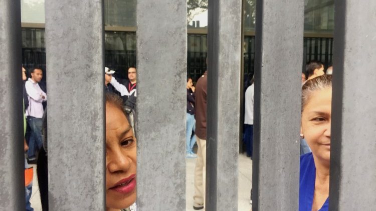 Folk köar utanför ett bankkontor i Caracas