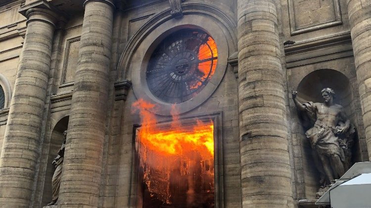 A member of the fire brigade reacts as Saint-Sulpice church is seen on fire in Paris
