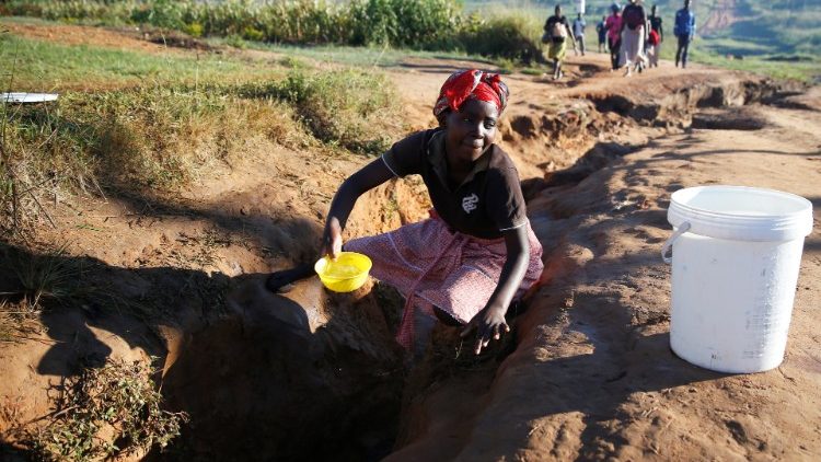 Une femme récupère de l'eau après le passage du cyclone Idai, en 2019.