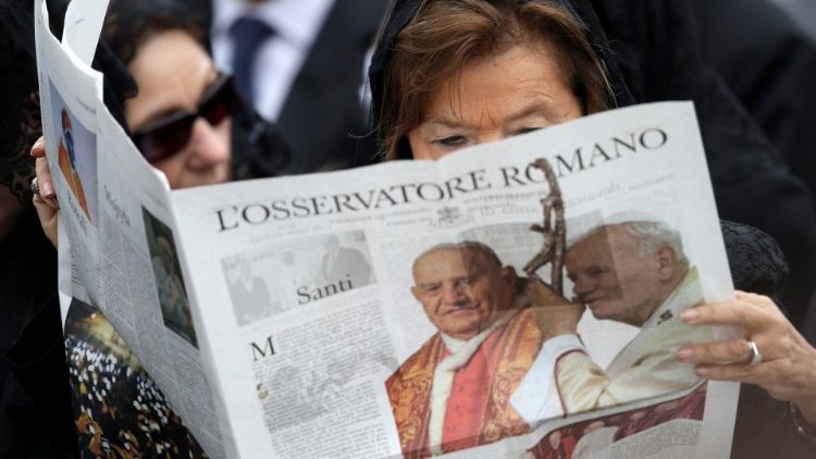 Une femme lisant L'Osservatore Romano lors de la canonisation de Jean-Paul II et Jean XXIII, le 27 avril 2014 au Vatican.